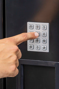 Hand bedient het cijfertoetsenbord voor de productkeuze op een drankenautomaat