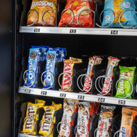 Binnenaanzicht van spiraalladen met snacks en genummerde schappen in een verkoopautomaat