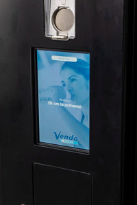 Touchscreen met startscherm 'tik om te activeren' en muntinworp op Vendo outdoor verkoopautomaat