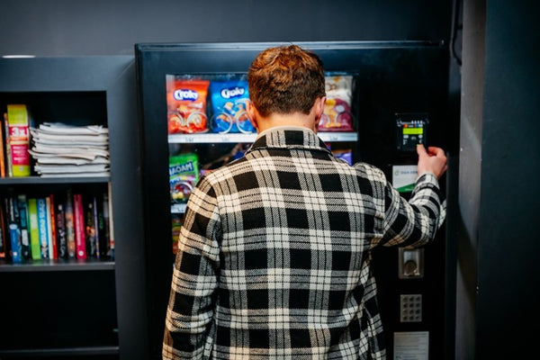 Bewoner haalt een snack uit de DGA-automaat in een wooncomplex