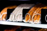 Vakuumverpackte Würste in den Spiralfächern eines Fleischautomaten, Nahaufnahme